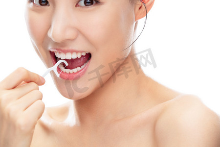 张牙舞爪狮子摄影照片_拿着牙线棒剔牙的青年女人