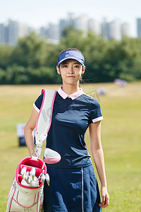 快乐的青年女人背着高尔夫球包