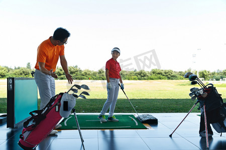 练习场上教练指导儿童打高尔夫