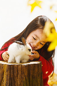 秋天温馨背景摄影照片_小女孩和小兔子