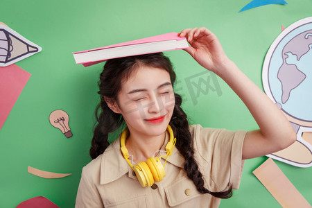 头顶书本的年轻女孩