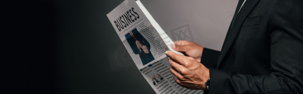 cropped view of african american businessman reading business newspaper on dark background, panoramic shot 