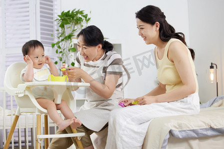 婴儿的日常摄影照片_月嫂和年轻妈妈一起喂宝宝吃饭