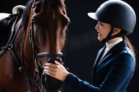 运动人物特写黑色摄影照片_关爱马匹的年轻女子