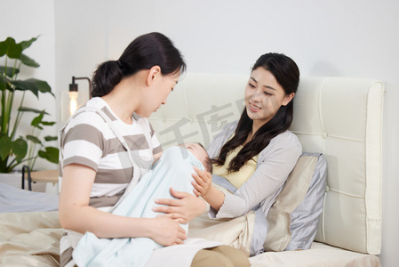 母子年轻女人摄影照片_保姆和年轻妈妈一起照顾宝宝