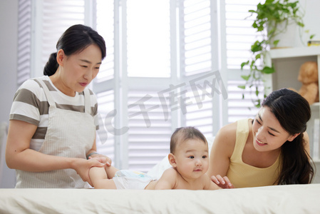 生活服务服务摄影照片_保姆和年轻妈妈一起照顾宝宝