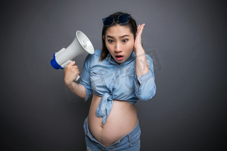 放假通知摄影照片_穿着时尚的孕妇拿着扩音器