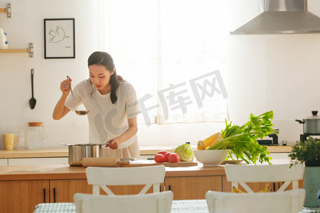 厨房欢乐摄影照片_青年女人在厨房里做饭