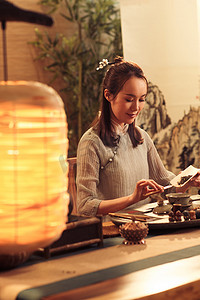 中国古典茶叶摄影照片_青年女人展示茶艺