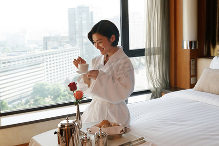 年轻女人在酒店房间里喝咖啡