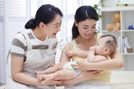 年轻亚洲家庭摄影照片_保姆和年轻妈妈一起照顾宝宝