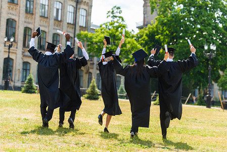 毕业摄影照片_大学园走在海角上庆祝青年毕业学生的后观