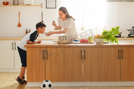 年轻亚洲家庭摄影照片_年轻妈妈和儿子在厨房