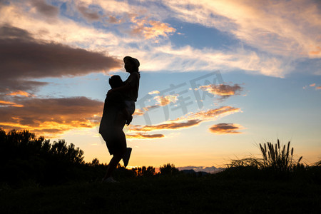人拥抱剪影摄影照片_夕阳下拥抱的快乐夫妇