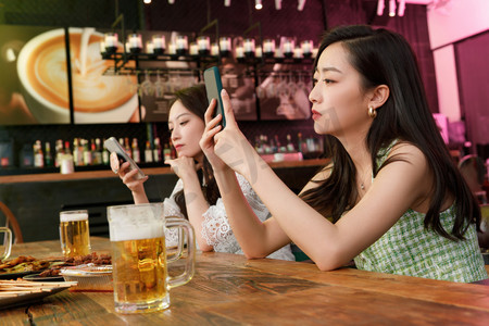 看手机的女人摄影照片_在酒吧里玩手机的青年女人