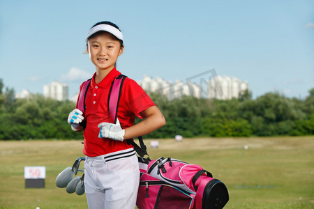 户外快乐儿童背着高尔夫球包