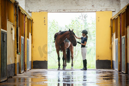 女子骑马摄影照片_畜舍门口的青年女子和马