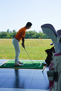 高尔夫练习场上青年男人打高尔夫