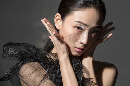 双手托着脸颊的时尚美女