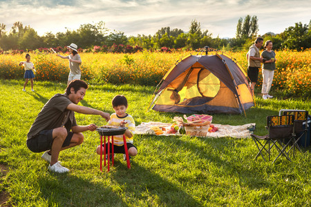 烧烤旅游摄影照片_欢乐的一家人在郊外野餐烧烤