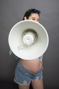 穿着时尚的孕妇拿着扩音器