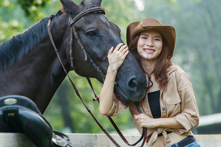 围栏旁的快乐个性女孩和马