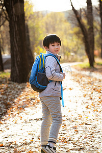 开学季摄影照片_秋天户外小路上背书包的小男孩