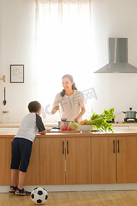 学生做饭摄影照片_年轻妈妈和儿子在厨房