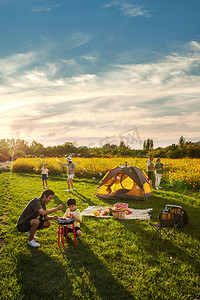 野炊摄影照片_欢乐的一家人在郊外野餐烧烤