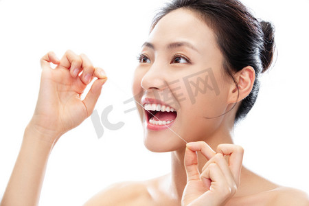 张牙舞爪狮子摄影照片_拿着牙线剔牙的青年女人