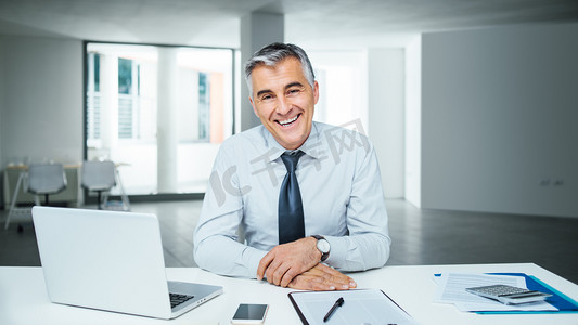 customer摄影照片_Confident businessman posing at desk