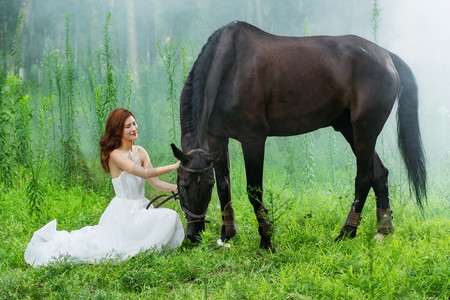 美女背摄影照片_草地上穿着婚纱的青年女人和马