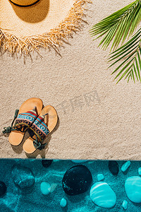 沙滩上时髦的拖鞋和草帽的顶级视图