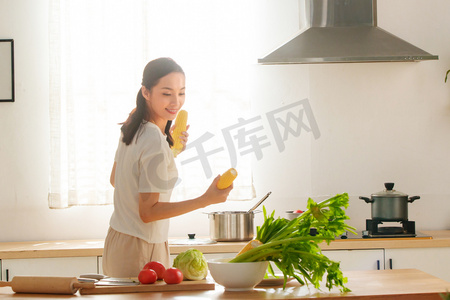 家庭做饭摄影照片_青年女人在厨房里做饭