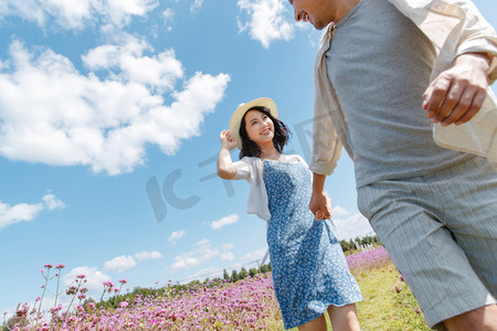 青年夫妇手牵手在花海里奔跑