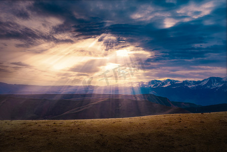 四条太阳光线摄影照片_新疆琼库什台大草原的丁达尔光摄影图配图