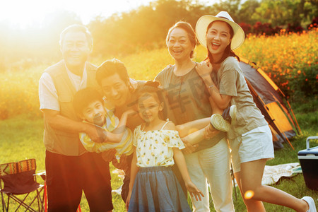 女孩抱着摄影照片_站着花丛中的快乐一家人