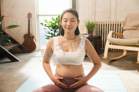 幸福孕妇摄影照片_孕妇在室内健身