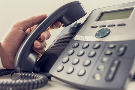 Closeup of male operator about to answer a phone call