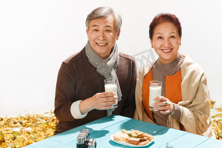 秋天落叶庭院摄影照片_老年夫妇喝牛奶