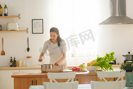 中国风手绘山水摄影照片_青年女人在厨房里做饭