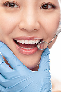 口腔器械摄影照片_牙医给青年女人检查牙齿
