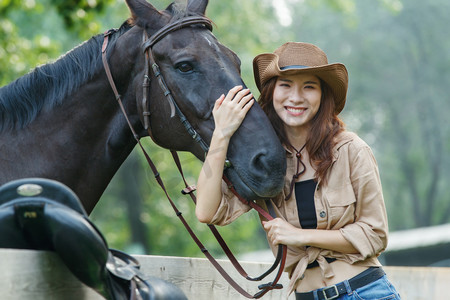 围栏旁复古快乐个性的女孩和马