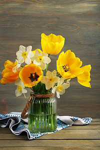 Beautiful bouquet of tulips and narcissus on wooden background