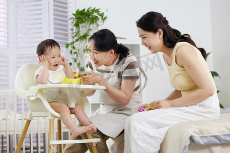 月嫂和年轻妈妈一起喂宝宝吃饭