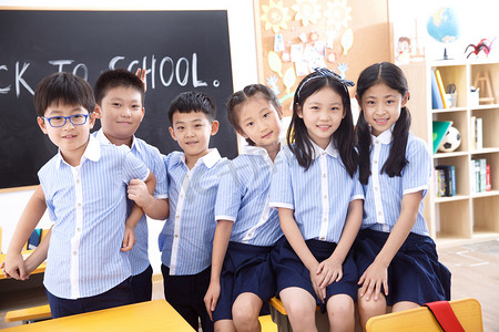 可爱的小学生在教室里和平手势,胜利手势,白色背景上孤立的两根手指