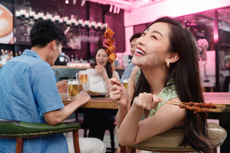 美食中国烧烤摄影照片_青年女人和朋友一起吃烧烤