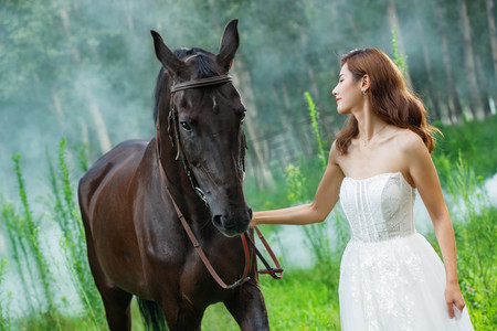 草丛中漂亮的年轻女人和马