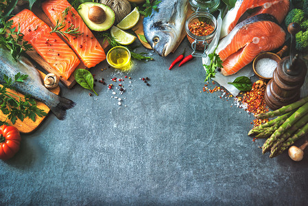 Assortment of fresh fish with aromatic herbs, spices and vegetab