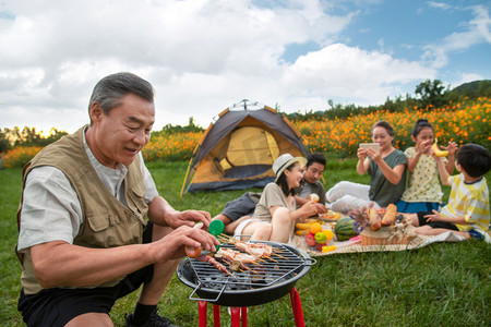 快乐家庭在郊外烧烤野餐